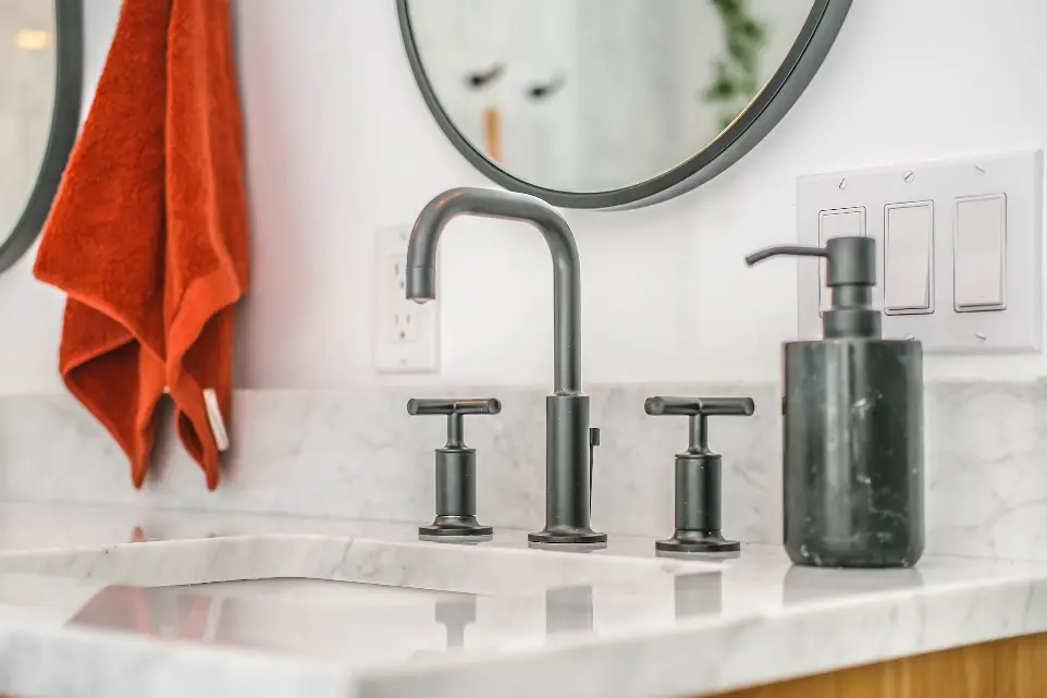 stainless steel faucet on white ceramic sink